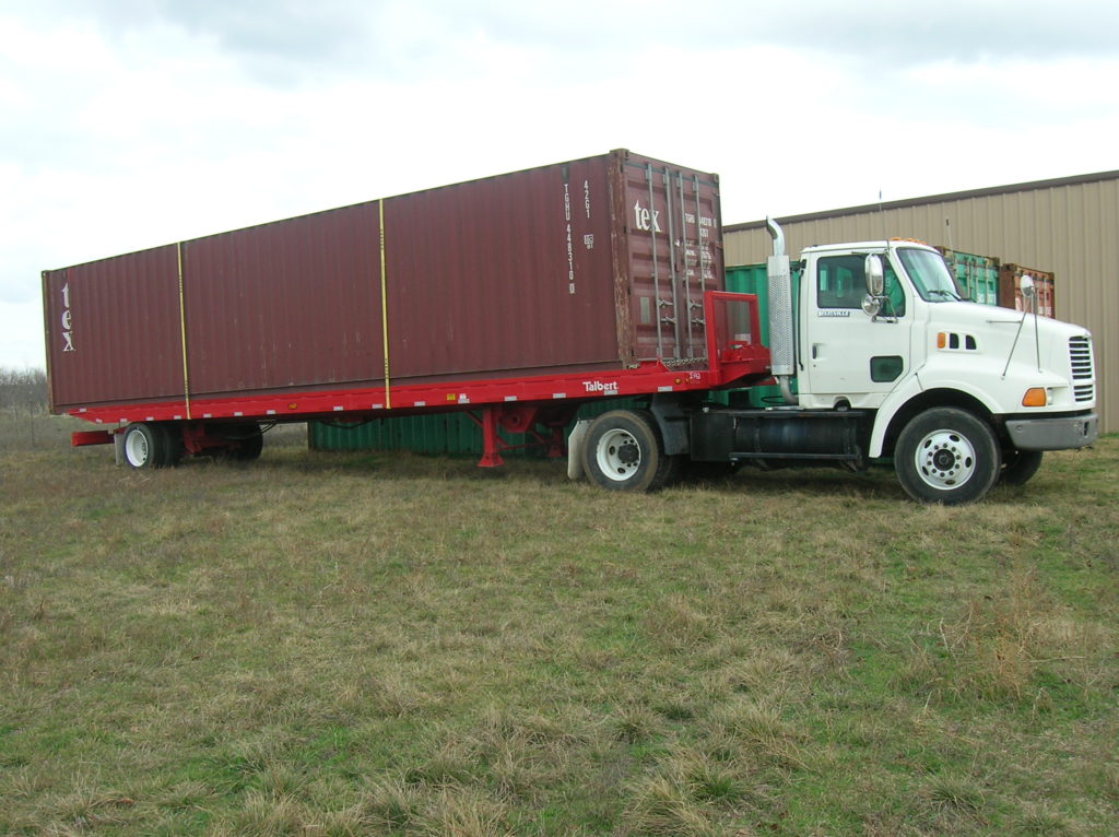 shipping container being delivered off of a truck